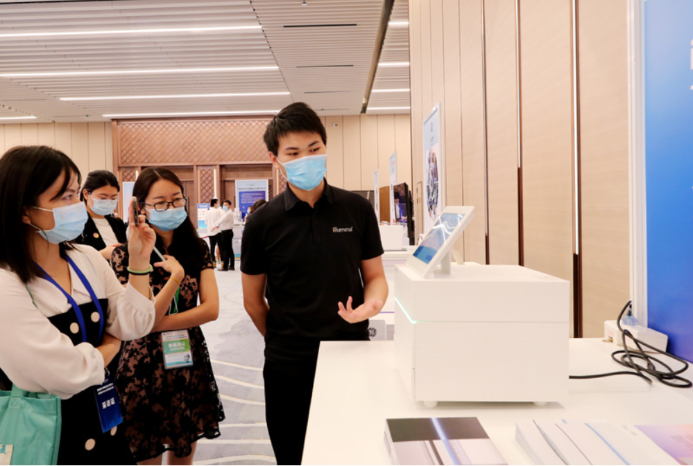 第四屆進(jìn)博會(huì)食品及農(nóng)產(chǎn)品展區(qū)、醫(yī)療器械及醫(yī)藥保健展區(qū)展前供需對(duì)接會(huì)的工作人員在介紹一臺(tái)測(cè)序儀展品